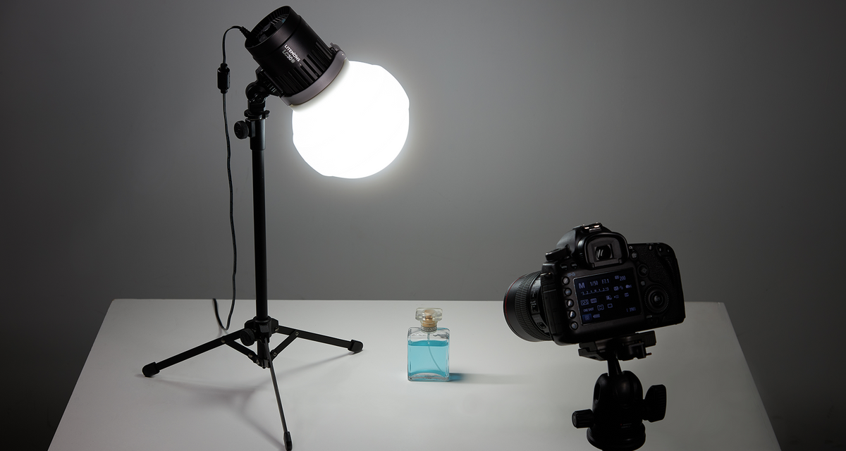 Godox Litemons LC30-series tabletop LED light with diffusion dome on a stand above a product table