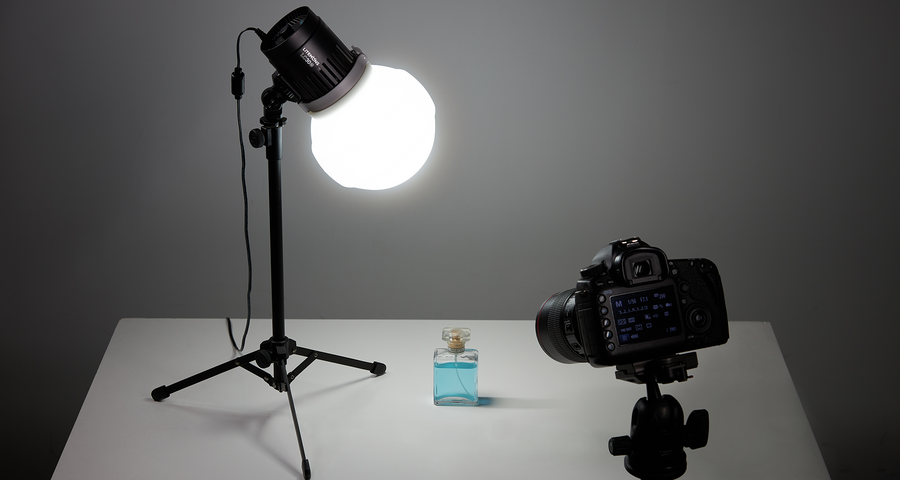 Godox Litemons LC30-series tabletop LED light with diffusion dome on a stand above a product table