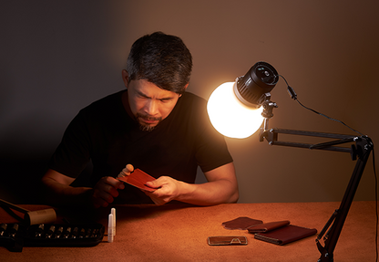 Godox Litemons LC30-series light on a desk clamp arm with diffusion dome above leatherwork