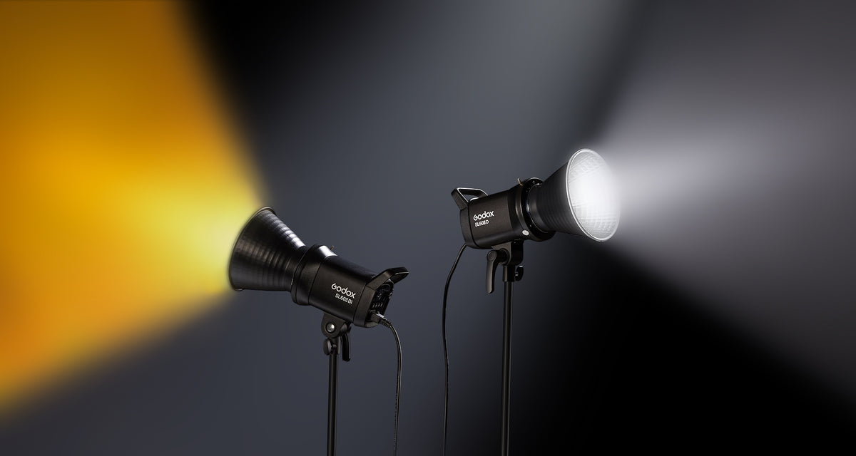Two Godox SL60II-series LED video lights on stands, one casting warm light and one casting white light
