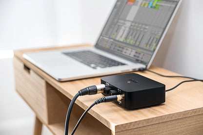 RØDE AI-1 audio interface with XLR and headphone cables connected next to a laptop