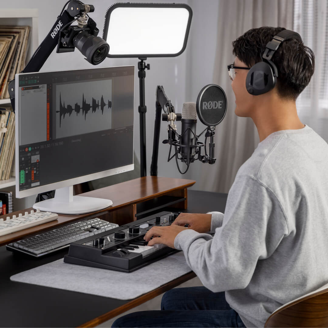 RØDE NT1 5th Generation microphone on a boom arm at a desk with a person wearing headphones